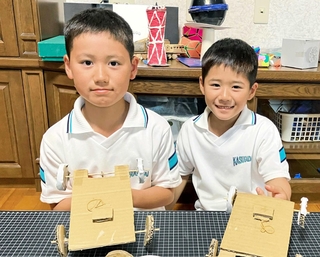 段ボールカーを手にする黒田英佑さん（左）、弟の悠太さん（右）＝神戸市西区内