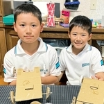 段ボールカーを手にする黒田英佑さん（左）、弟の悠太さん（右）＝神戸市西区内