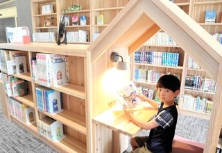 児童書の本棚の間にある隠れ家スペースで本を読む石川諒真さん＝神河町粟賀町、図書コミュニティー公園