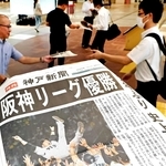 出勤する人らに配布した阪神リーグ優勝を伝える神戸新聞の号外＝８日午前、神戸市中央区、デュオこうべ