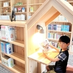 児童書の本棚の間にある隠れ家スペースで本を読む石川諒真さん＝神河町粟賀町、図書コミュニティー公園
