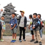 案内役の後藤芳孝さん（左）から国宝松本城の魅力を聞くこども記者ら＝長野県松本市