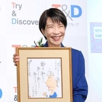 選考委員の漫画家やくみつるさんの直筆イラストを手にする高市首相＝東京都千代田区