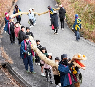 長さ約１１メートルの蛇をたくさんの子どもたちと地元住民で担ぐ＝南あわじ市倭文安住寺
