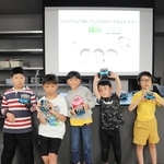 科学の好きなイベントの参加者ら。手に持つプログラミングロボットを動かした。右から２人目が林さん＝神戸市中央区港島の「バンドー神戸青少年科学館」