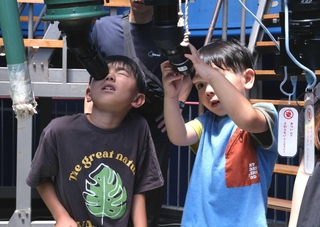 望遠鏡をのぞきこんで太陽を観察する子どもら＝バンドー神戸青少年科学館