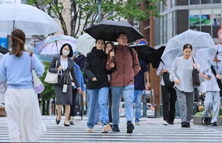 雨の中を歩く人たち。気温が上がらず厚着の人も＝６月２日、神戸市中央区