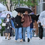 雨の中を歩く人たち。気温が上がらず厚着の人も＝６月２日、神戸市中央区