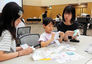 月経の仕組みとナプキンについて学ぶ子どもたち。「こんなに種類があるんだ」と驚きの声も＝三田市駅前町１、市まちづくり協働センター