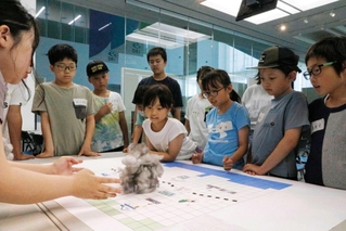 ゲリラ豪雨について学ぶワークショップで、雨雲の模型を見る小学生ら＝人と防災未来センター