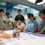 ゲリラ豪雨について学ぶワークショップで、雨雲の模型を見る小学生ら＝人と防災未来センター