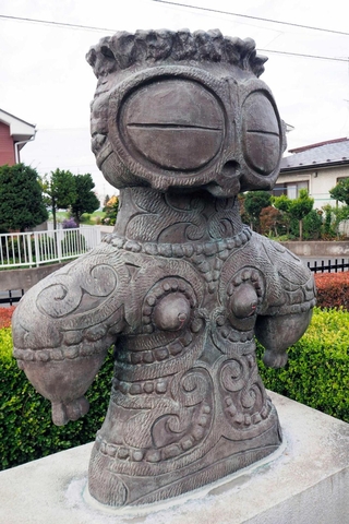遺跡から出土した「遮光器土偶」をかたどった像＝青森県八戸市の「みどりと彫刻のふれあい散歩道」