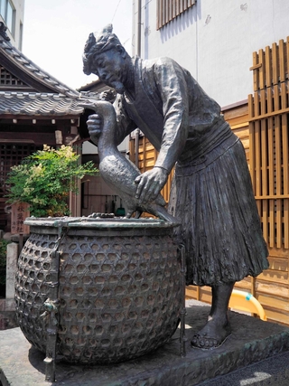 えぼし、こしみの姿で、ウをかわいがっているような鵜匠の像＝岐阜市の鵜飼観覧船事務所前