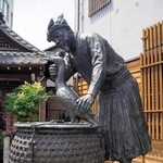 えぼし、こしみの姿で、ウをかわいがっているような鵜匠の像＝岐阜市の鵜飼観覧船事務所前