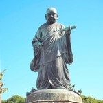 「立正安国論」の巻物を持つ日蓮の大銅像＝福岡市博多区