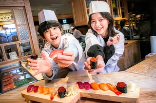 自分でにぎったすしを持つ柊木陽太さんと藤田蒼果さん＝３月、東京・銀座