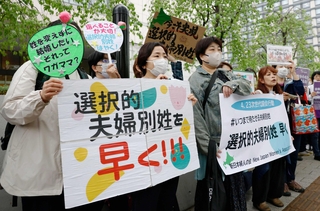 選択的夫婦別姓の早期実現を目指し、国会前で集会をする女性団体のメンバーら＝４月