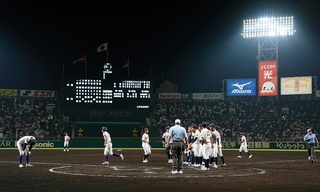 全国高校野球選手権第２日に行われた「朝夕２部制」のナイター。右側は天理高校に勝利し整列する鳴門高校ナイン＝甲子園