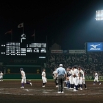 全国高校野球選手権第２日に行われた「朝夕２部制」のナイター。右側は天理高校に勝利し整列する鳴門高校ナイン＝甲子園