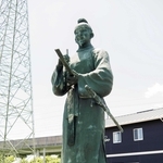 筆を持ち、歌をよむ大伴家持像＝鹿児島県薩摩川内市の「万葉の散歩道」