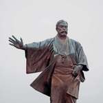 生家のとなりに手を広げて立つ岩崎弥太郎の銅像＝高知県安芸市