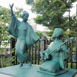 三味線をひき、おどりを教えているような永田いねの像（右）＝熊本市中央区