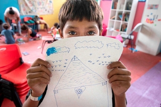 自分でえがいた絵を手に持つアレックスさん（日本ユニセフ協会提供）