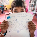 自分でえがいた絵を手に持つアレックスさん（日本ユニセフ協会提供）