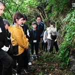 前川民間防空壕群の壕口を見つめる参加者＝１月、沖縄県南城市玉城前川