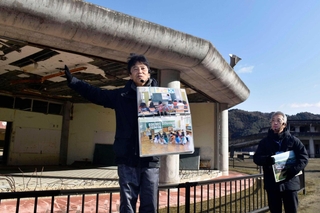 こわれた校舎の前で、かつての大川小学校の様子を説明する佐藤敏郎さん（左）と鈴木典行さん＝１月、宮城県石巻市