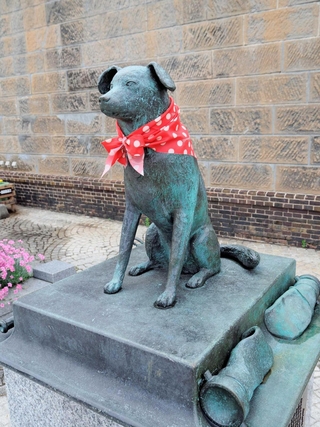 首にバンダナを巻いた消防犬ぶん公の銅像＝北海道小樽市