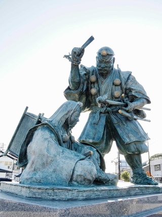 おうぎで源義経をなぐろうとする弁慶の像＝富山県高岡市のＪＲ伏木駅前