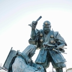 おうぎで源義経をなぐろうとする弁慶の像＝富山県高岡市のＪＲ伏木駅前