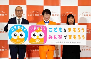 「こまもろう」のパネルを手にして新しい仕組みをアピールするこども家庭庁の渡辺由美子長官（右）ら＝２０２５年１２月、東京・霞が関
