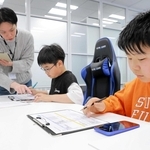 ゲームの品質管理を担当する池田さん（左）の説明を聞き、デバッグを体験する酒井悠太朗さん（中央）と松森優槻さん（（Ｃ）ＳＥＧＡ）