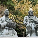 かんむりをかぶる継体天皇（右）と花かごを持つ照日の前の銅像＝福井県越前市の万葉の里味真野苑