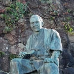 右手にせんすを持つ清水次郎長の銅像＝静岡市清水区の梅蔭禅寺