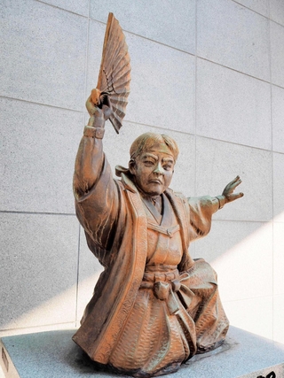陣羽織を着て「オッペケペー節」を歌う川上音二郎の像＝福岡市博多区