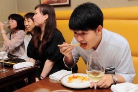 参加者との交流を忘れ、料理に夢中の末吉佳希記者＝西灘裏街レストラン
