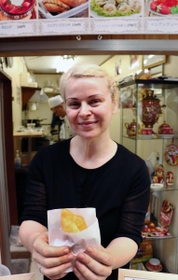 １番人気のピロシキを手にする店主のオルガさん＝ロシアンピロシキ