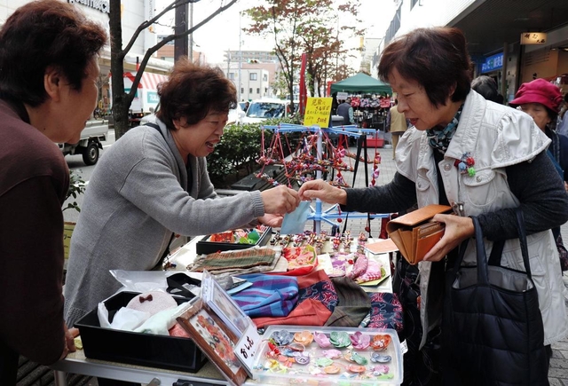 「ぽっぺん工房市座」で小物を買い求める客＝長田神社前商店街