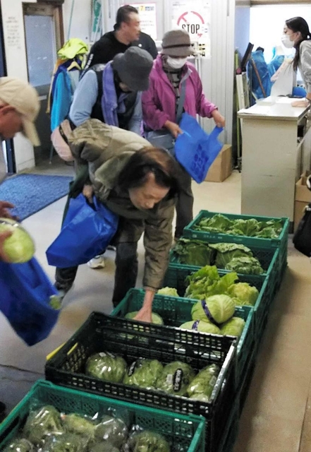 野菜を品定めする地域住民ら＝池田専売所