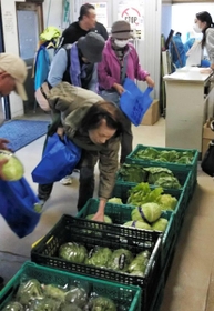 野菜を品定めする地域住民ら＝池田専売所