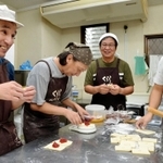パンの仕込みをする石倉さん（左から３人目）とメンバーら。笑みもこぼれる＝くららべーかりー