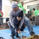 遊具「竹ぽっくり」を作るために竹を切る子ども