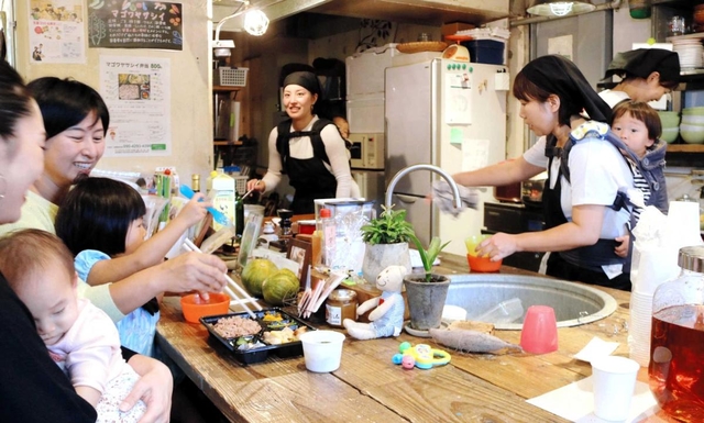 子どもをおんぶしながら調理や接客をするスタッフ＝神戸市長田区庄田町３