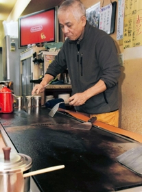 使い込まれたカウンターの鉄板。お好み焼きを焼ける熱さになるまで２０分ほどかかるという＝長田区水笠通４、お好み焼き店「日月」