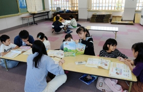 「オリニソダン」の机を囲んでハングルを学ぶ子どもたち＝蓮池小