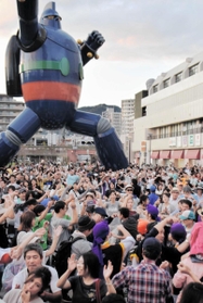 １０月の琉球祭で、鉄人２８号の実物大モニュメントの前で踊る参加者ら＝若松公園