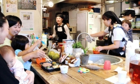 子どもをおんぶしながら調理や接客をするスタッフ＝神戸市長田区庄田町３